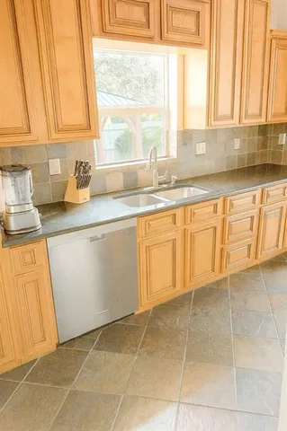 a kitchen with a sink a counter top space and cabinets