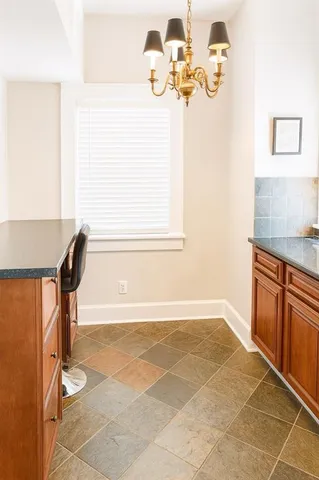 a bathroom with a granite countertop sink a toilet and a mirror