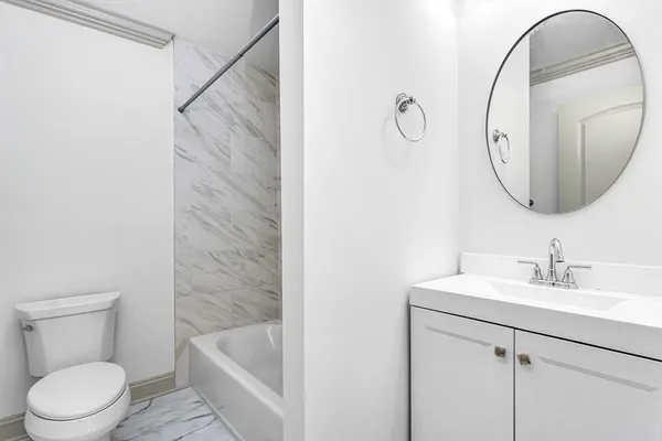 a bathroom with a sink a toilet and a mirror