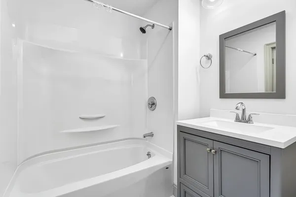 a bathroom with a bathtub shower sink and a mirror