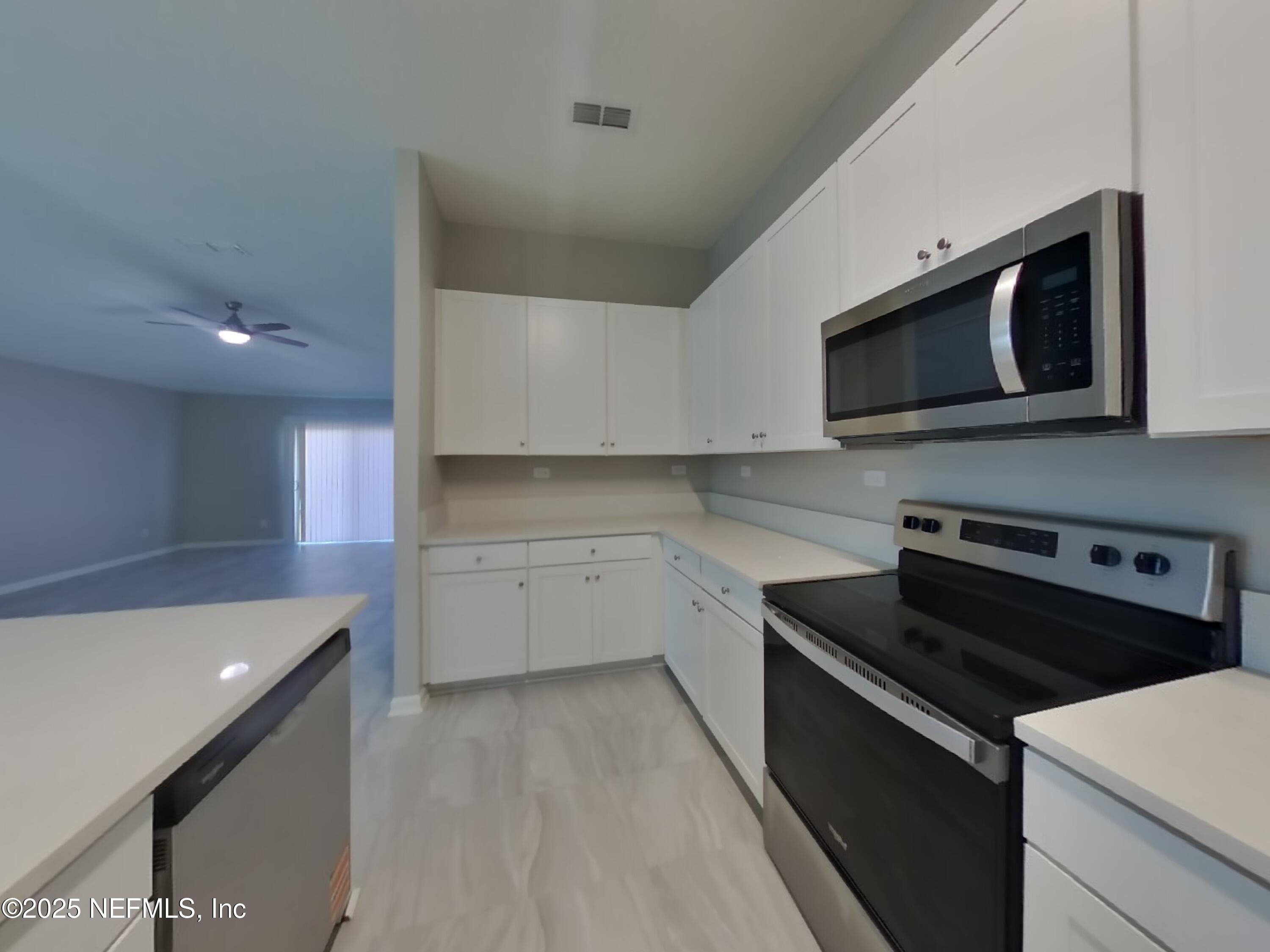 4889 Morning Rise Circle Jacksonville, FL 32218 - Photo 5 of 15 a kitchen with a stove microwave and sink