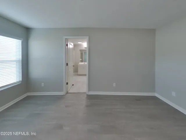 an empty room with windows and closet