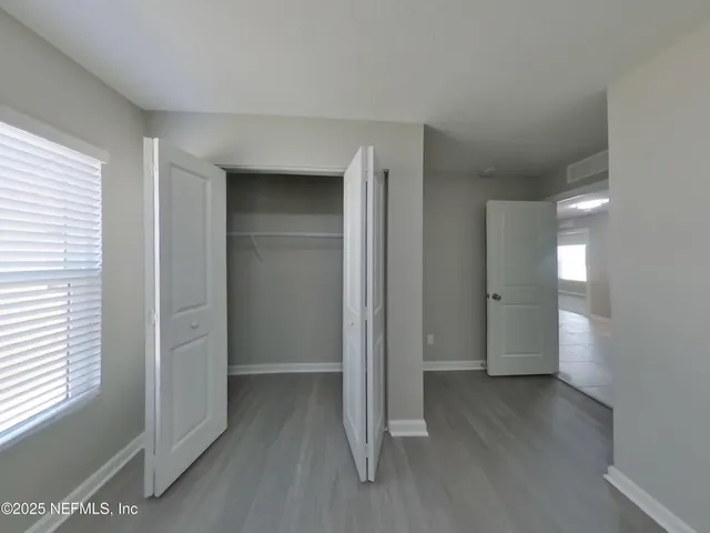 a view of hallway with bathroom and wooden floor