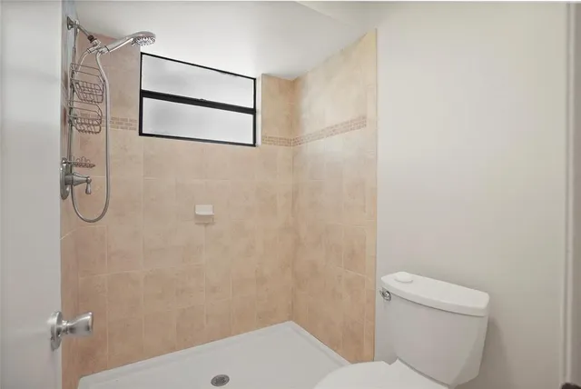 a bathroom with a toilet and a shower