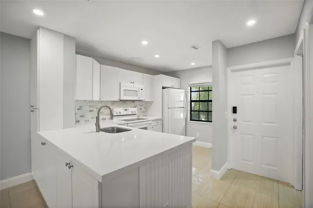 a kitchen with stainless steel appliances a refrigerator sink and cabinets