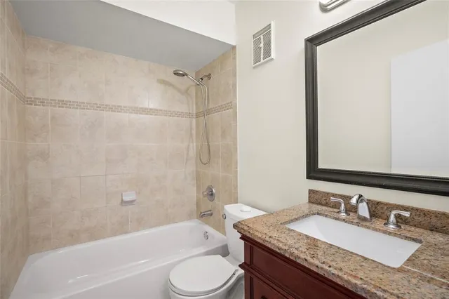 a bathroom with a granite countertop sink toilet mirror and shower