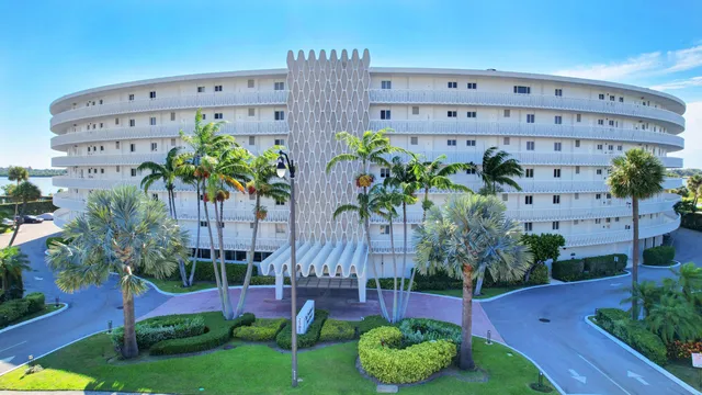a view of a tall building with a yard and potted plants
