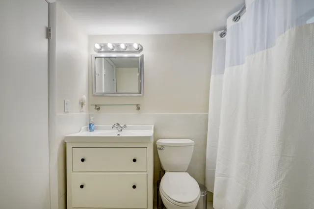 a bathroom with a sink a toilet and a mirror