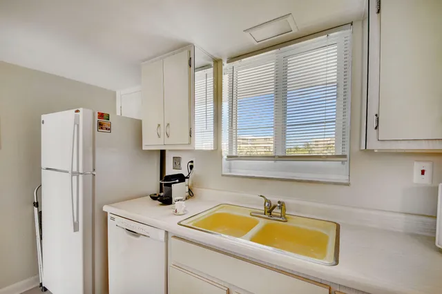 a kitchen with a refrigerator a sink and cabinets