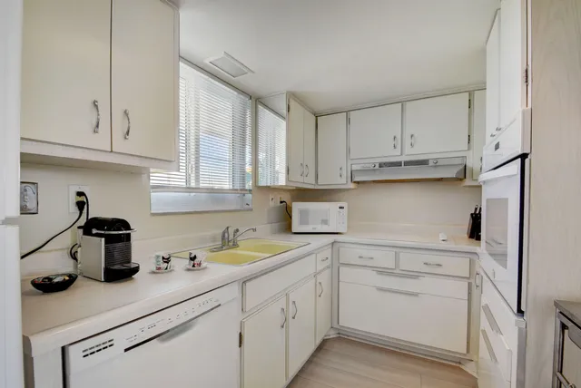 a kitchen with white cabinets and a sink