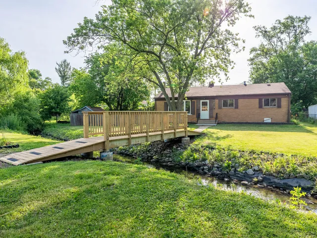 a view of a house with a yard and sitting area