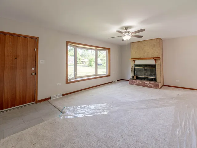 an empty room with windows and ceiling fan