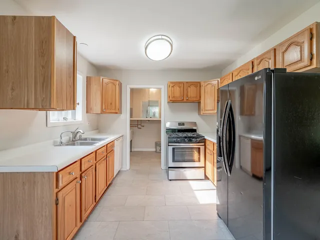 a kitchen with stainless steel appliances a refrigerator sink and stove