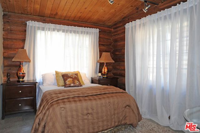 a bed sitting in a bedroom next to a window