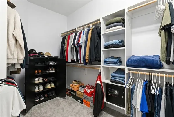 a view of walk in closet with clothes and shoes