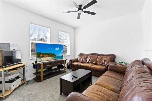 a living room with furniture a flat screen tv and a couch