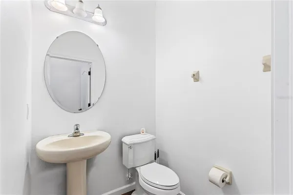 a bathroom with a toilet a sink and mirror