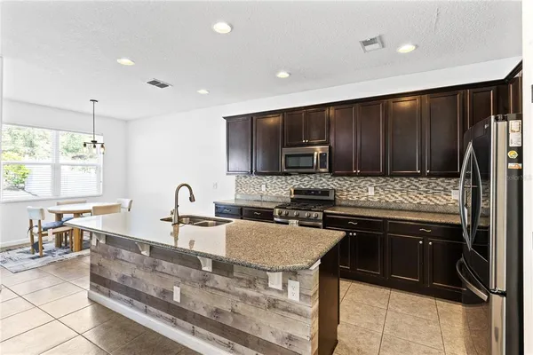 a kitchen with kitchen island granite countertop a sink stove and refrigerator