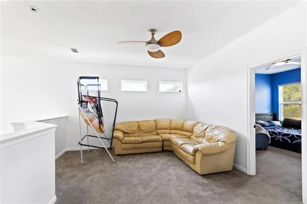 a living room with furniture and a gym machine