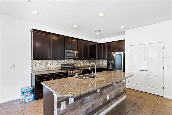 a kitchen with stainless steel appliances granite countertop a sink and a refrigerator