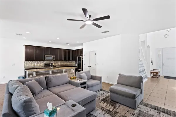 a living room with furniture kitchen view and a window