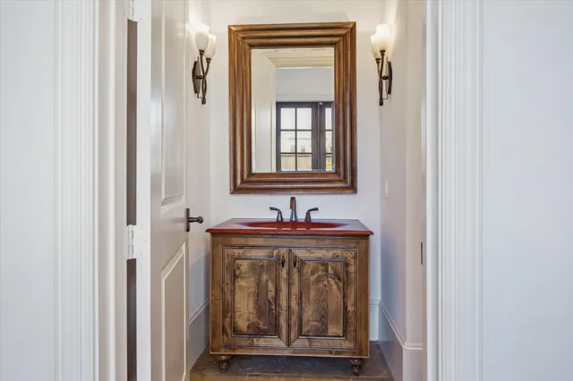 a bathroom with a sink a mirror and a window