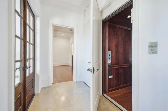 a view of a hallway with wooden floor and closet