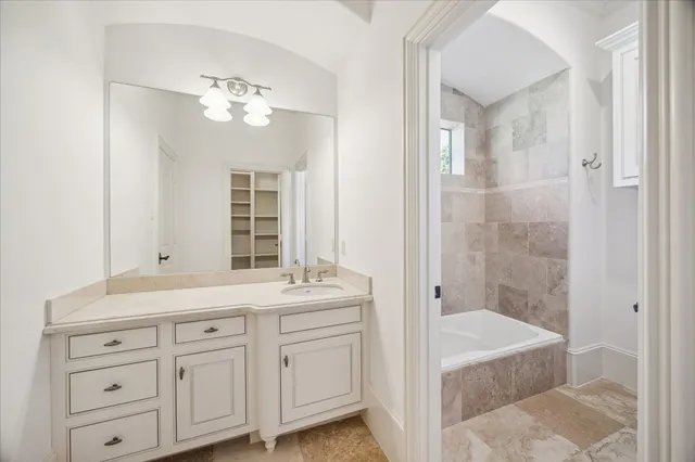 a bathroom with a sink double vanity granite tub and shower