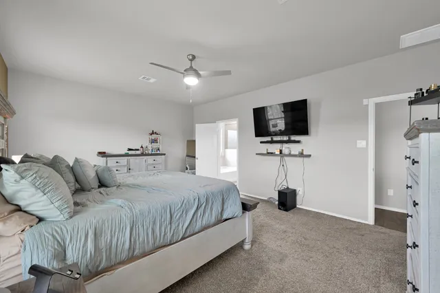 a bedroom with a bed tv and a window