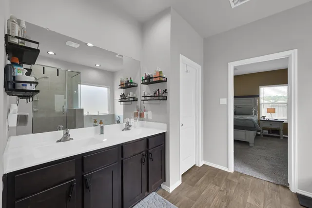 a en suite bathroom with a double vanity sink and a mirror