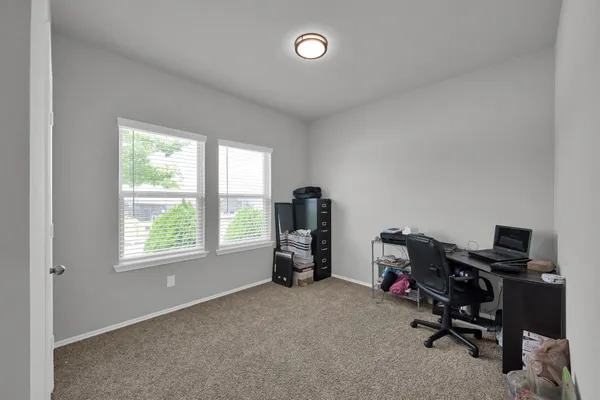 a view of a workspace with furniture and a window
