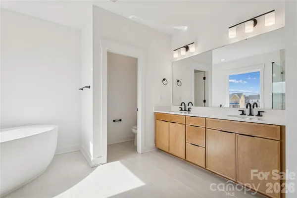 a spacious bathroom with a double vanity sink a mirror and a bathtub