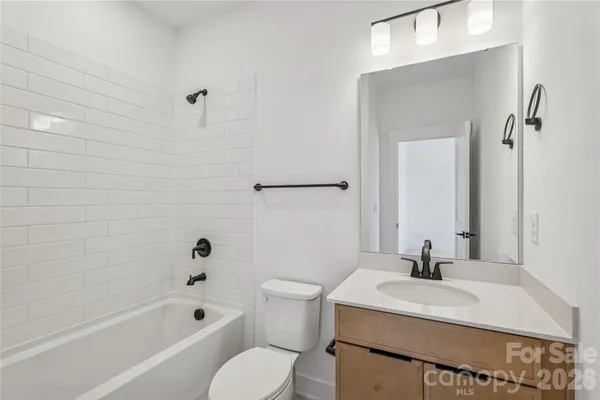 a bathroom with a sink toilet vanity and shower