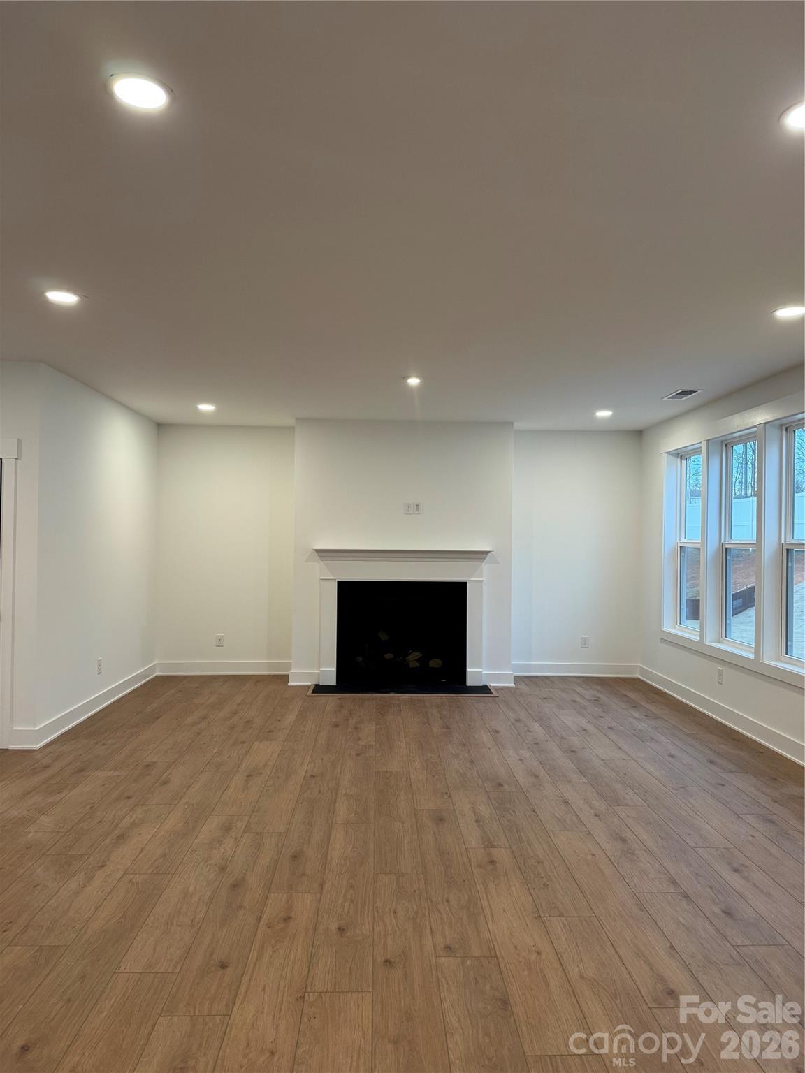 3024 Griffs Pond Road, Unit 388 Charlotte, NC 28269 - Photo 5 of 12 an empty room with wooden floor and windows