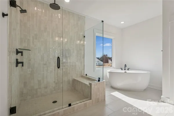 a bathroom with a bathtub shower sink mirror and toilet