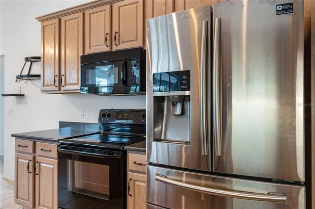 a kitchen with stainless steel appliances granite countertop a refrigerator and a stove