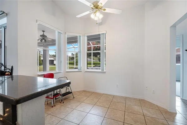 a room with chandelier fan and windows