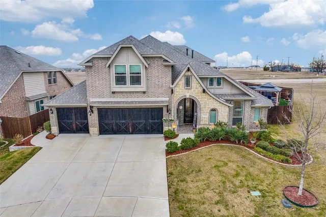 a view of a white house with a yard and potted plants