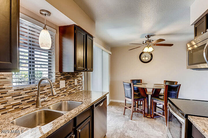 540 South West Road, Unit 29 Wickenburg, AZ 85390 - Photo 2 of 9 a kitchen with a table chairs sink and cabinets