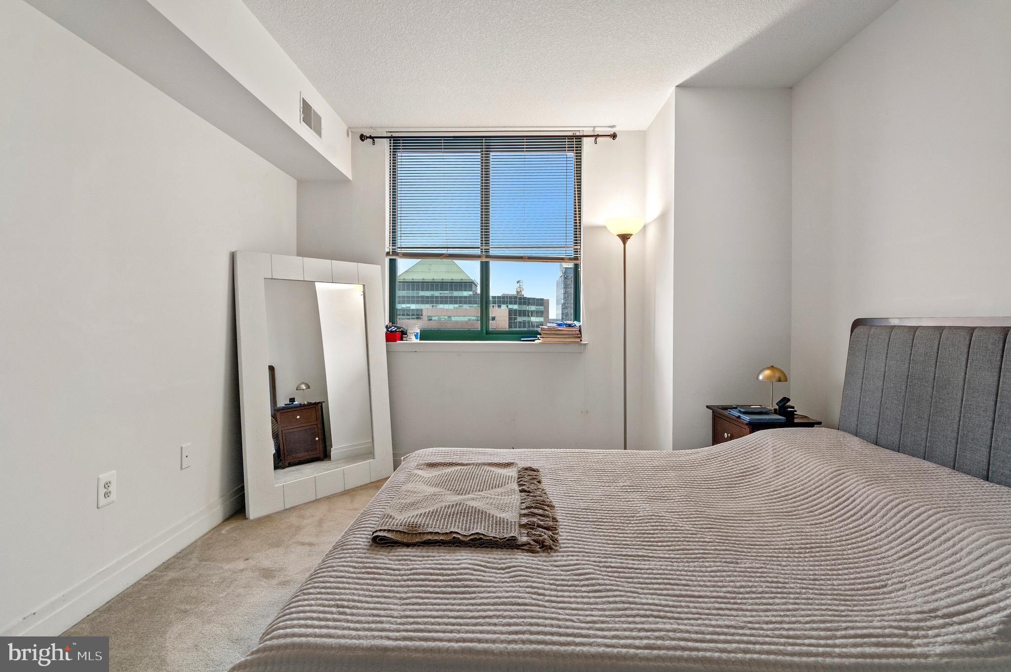 414 Water Street, Unit 2504 Baltimore, MD 21202 - Photo 11 of 20 a bedroom with a bed and a mirror