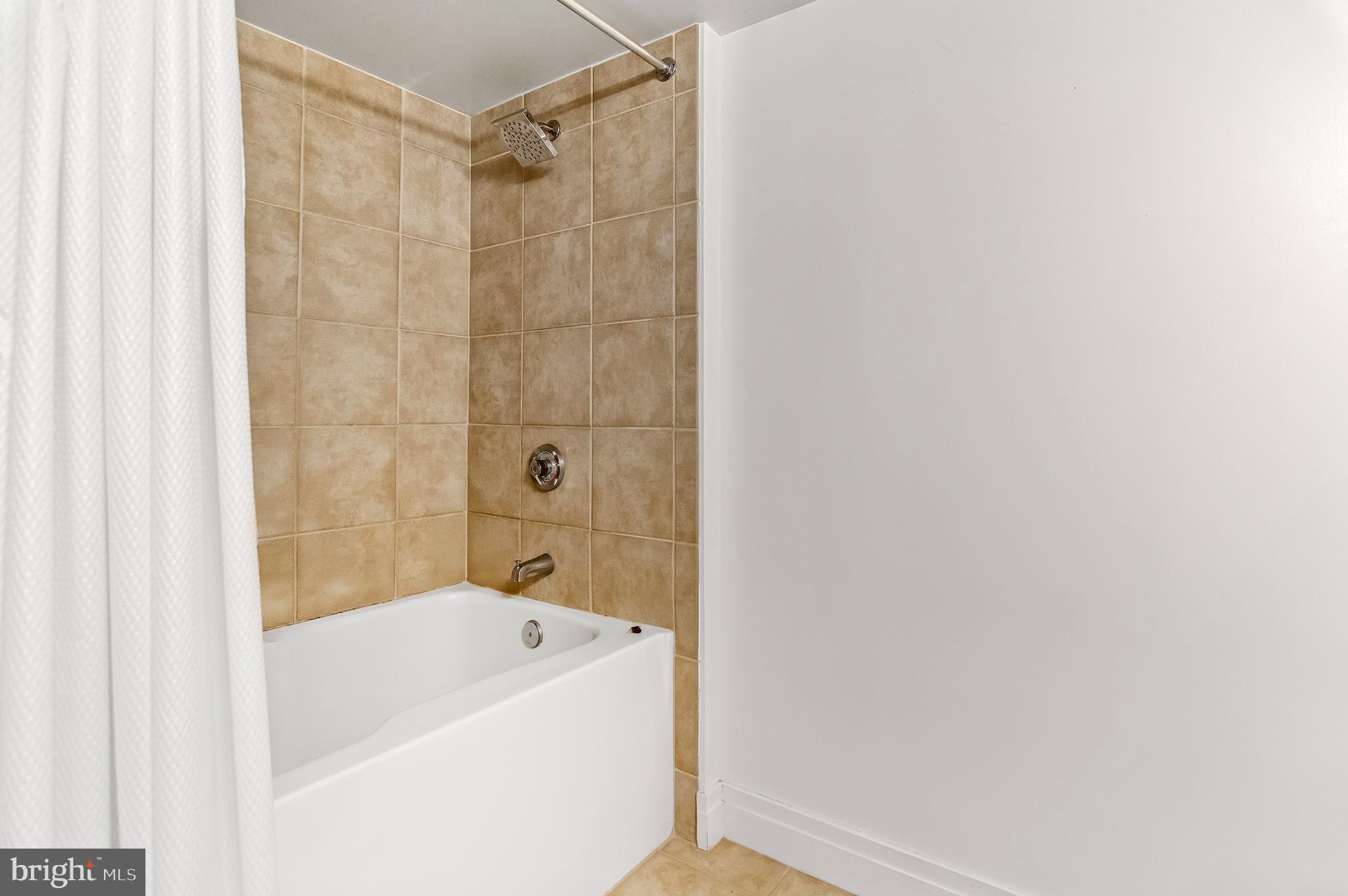 414 Water Street, Unit 2504 Baltimore, MD 21202 - Photo 12 of 20 a bathroom with a bathtub and a shower