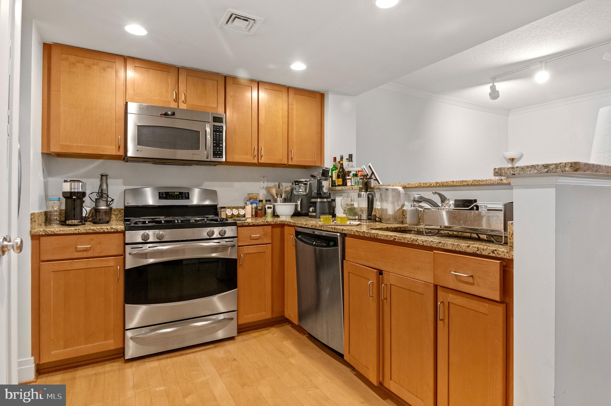 414 Water Street, Unit 2504 Baltimore, MD 21202 - Photo 6 of 20 a kitchen with stainless steel appliances granite countertop a stove a sink and a refrigerator