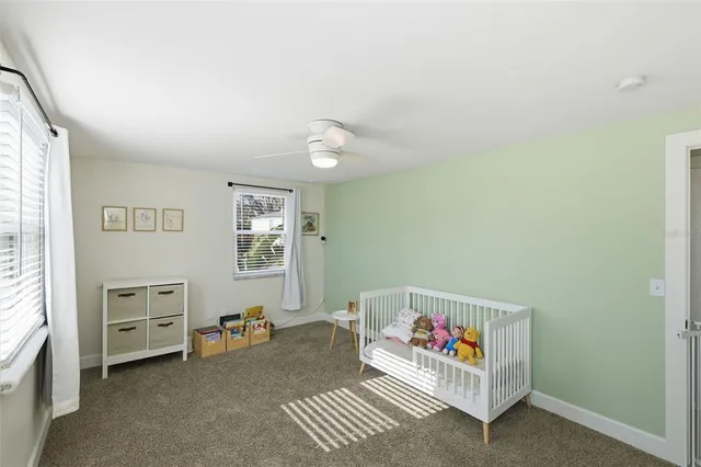 a front view of a house with a yard covered with snow and trees