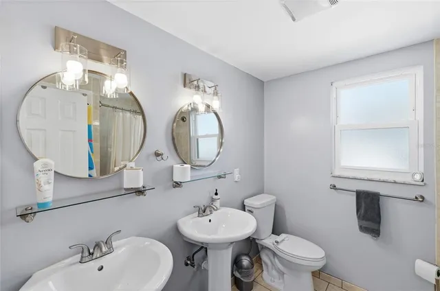 a front view of a house with a yard outdoor seating and covered with trees