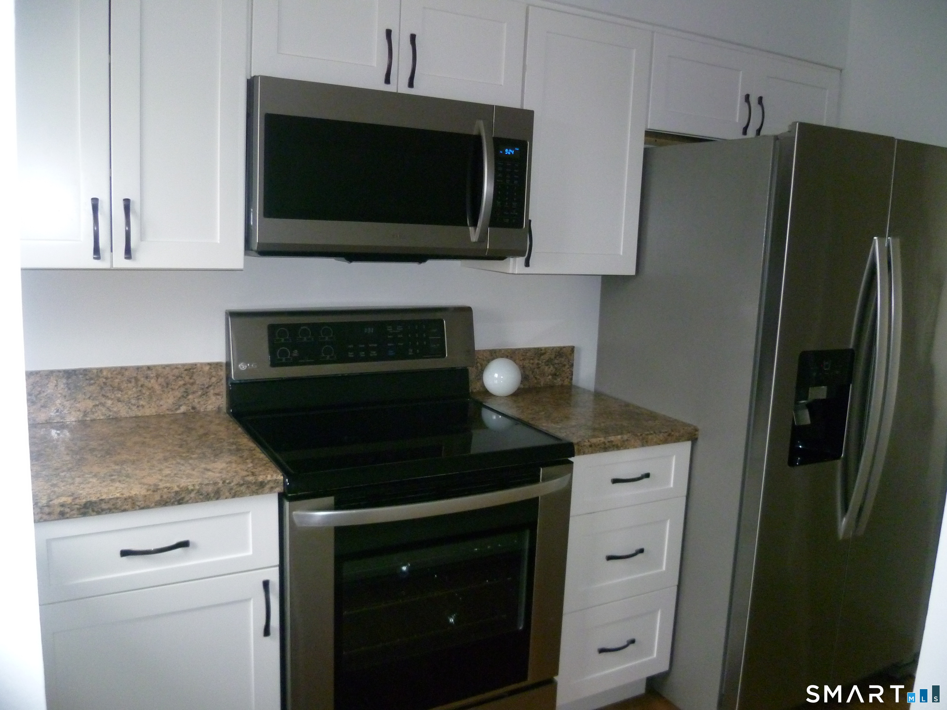 560 Yale Avenue, Unit 4 Meriden, CT 06450 - Photo 3 of 8 a kitchen with stainless steel appliances white cabinets and a stove top oven