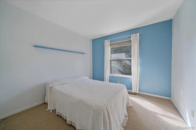 a bed sitting in a bedroom next to a window