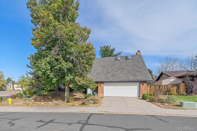 front view of house with a yard and potted plants