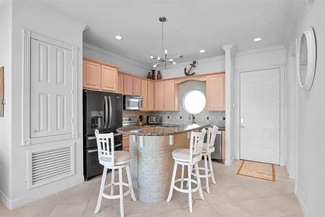 a view of a dining room with furniture a chandelier and kitchen view