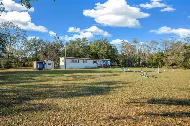 a view of a fountain in front of a house with a big yard