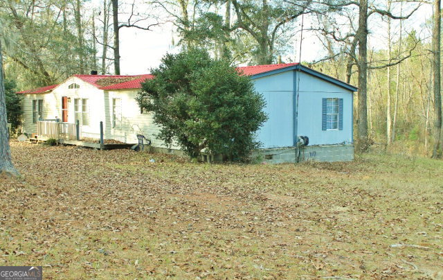 a backyard of a house with table and chairs